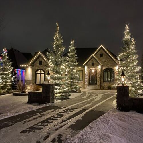 Contemporary home with large windows and bright roofline holiday lighting installation creating a festive look